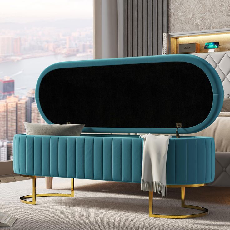 a bed with a blue velvet upholstered headboard and foot stool in front of a cityscape