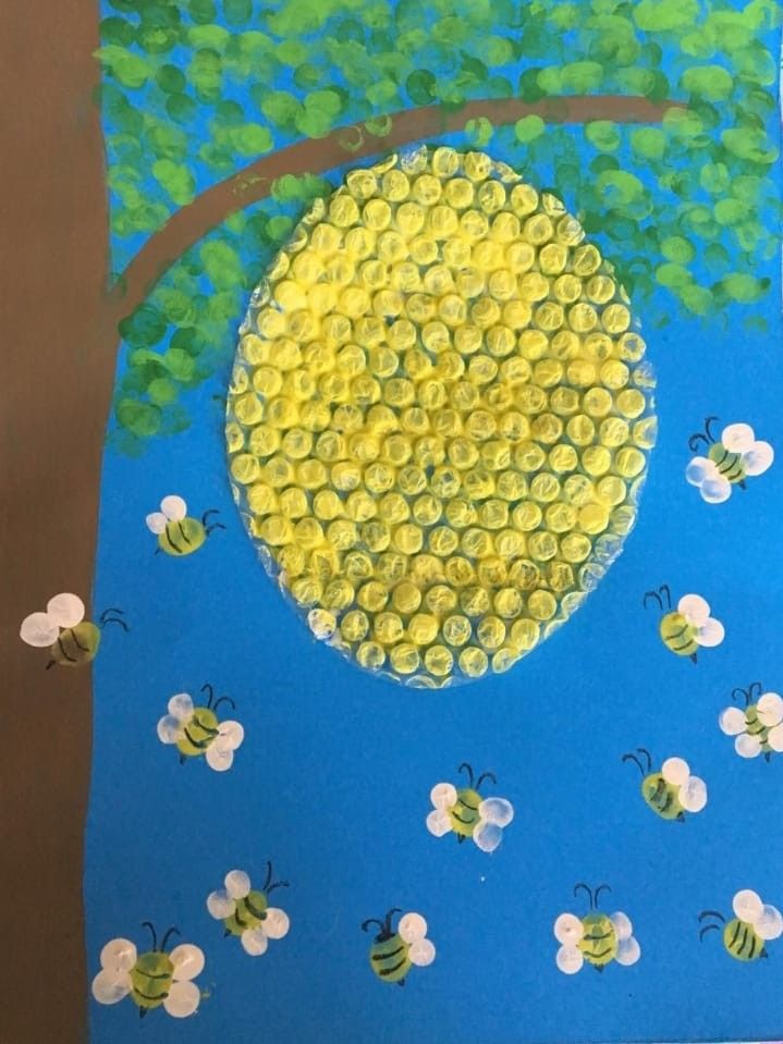 the bees are flying around the tree on the blue paper with yellow and white circles