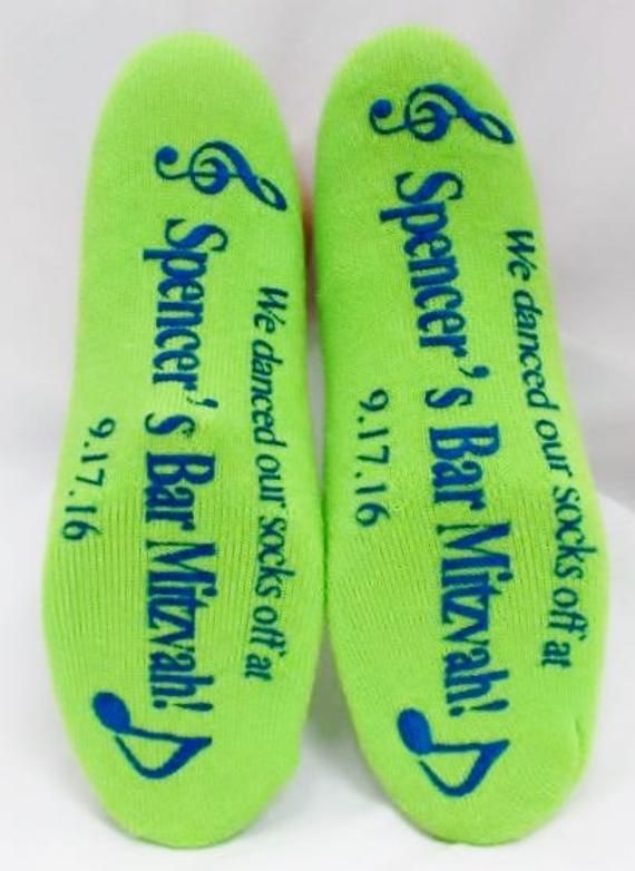 two green socks with blue writing on them