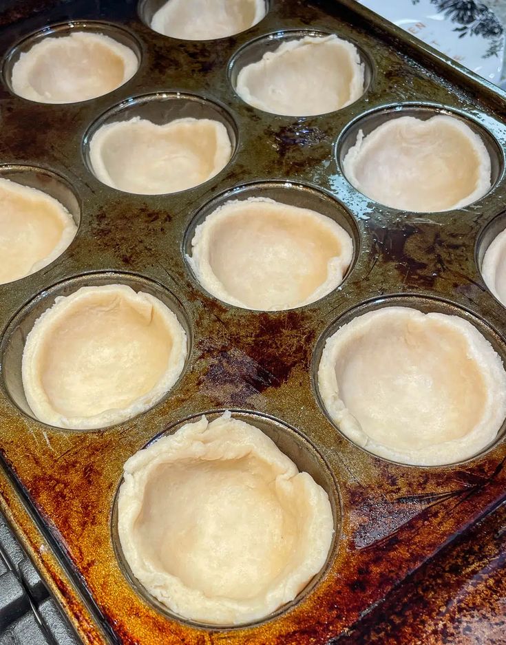 a pan filled with uncooked pies on top of a stove