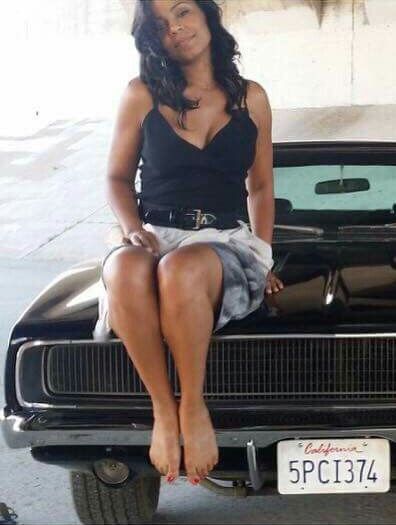 a woman sitting on the hood of a car