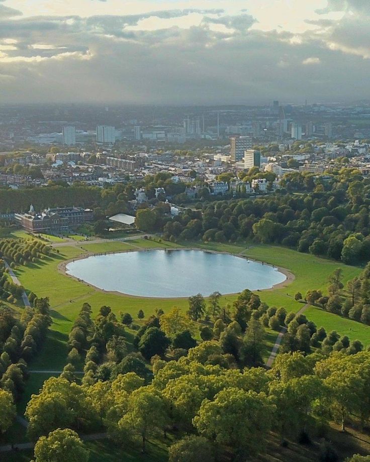 an aerial view of a park with a lake in the middle and trees surrounding it