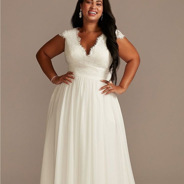 a woman in a white dress posing for the camera with her hands on her hips