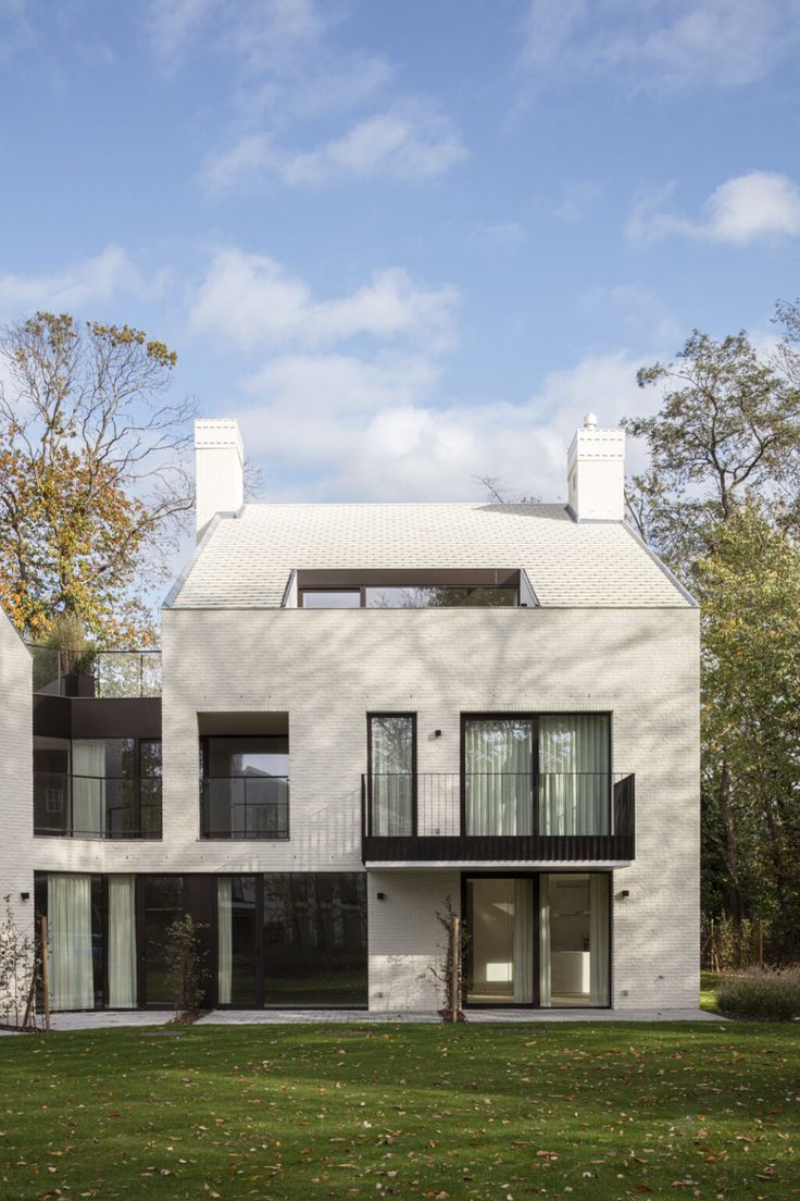 a large white house sitting on top of a lush green field