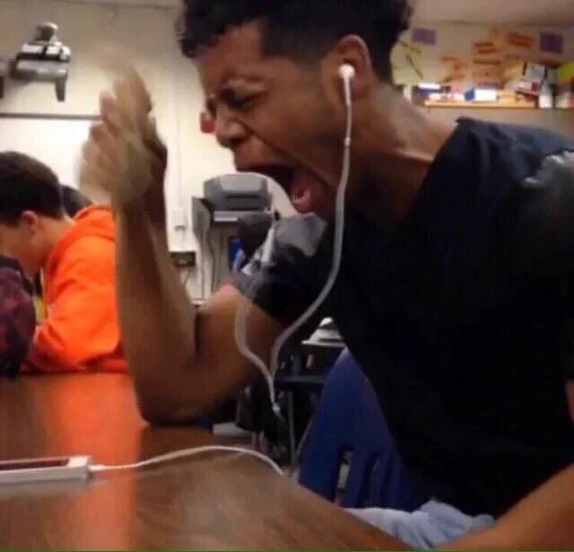 a man sitting at a table with his mouth open and headphones in his ears