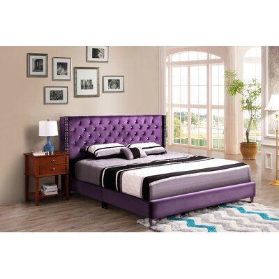 a bed with purple upholstered headboard and foot board is in a room