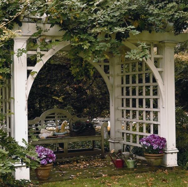 an arbor with potted plants and flowers on it