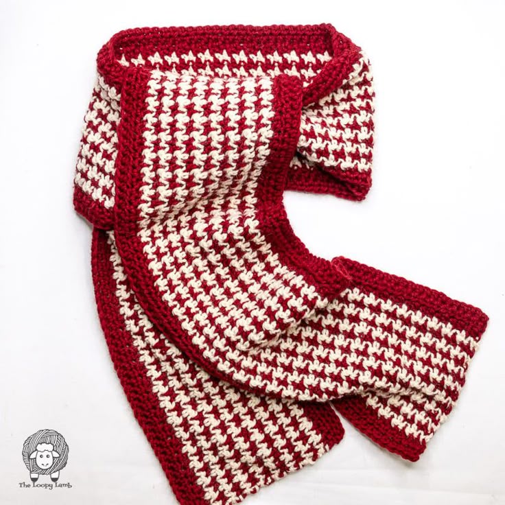 two red and white knitted scarfs laying on top of each other