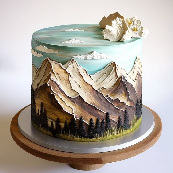 a decorated cake with mountains and trees on it