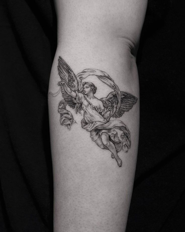 a black and white photo of an angel tattoo on the leg, with flowers around it