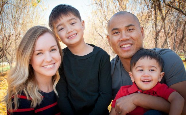 a family posing for a photo in the park