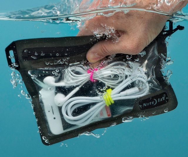 a person holding an electronic device in the water with their hand on top of it