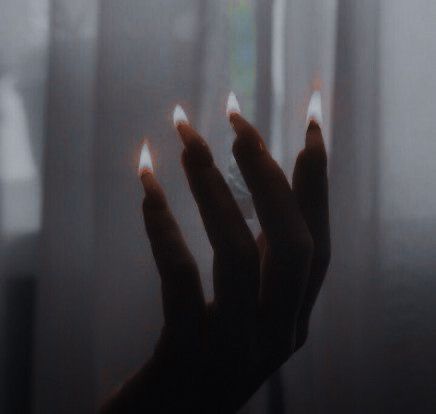 a person holding out their hands in front of a window with light coming from them