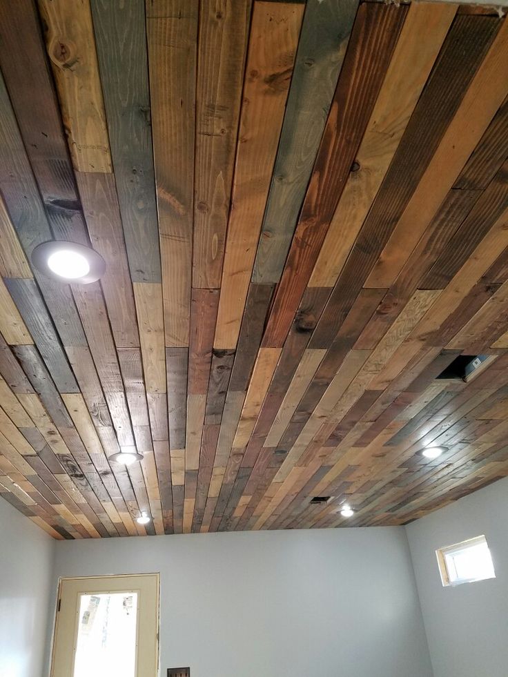 an unfinished ceiling with wood planks and lights