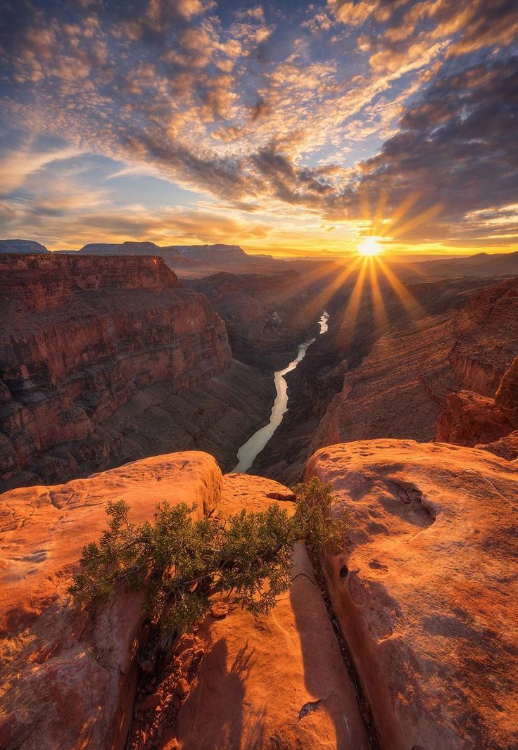 the sun is setting over canyon and river