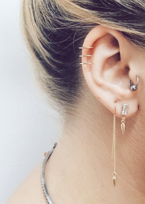 a close up of a person with ear piercings on their ears and behind the ear