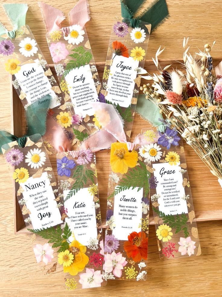 some flowers are sitting on a table with tags attached to the top and bottom of them