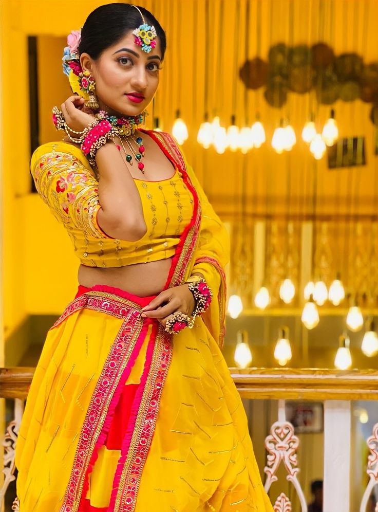 a woman in a yellow and red outfit posing for the camera with her hands on her hips