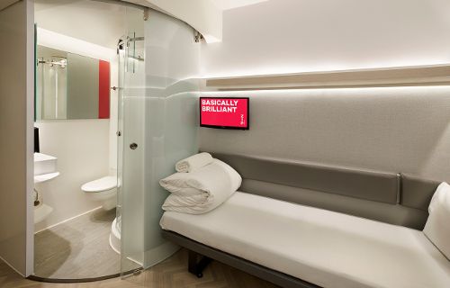 a bathroom with a bed, shower and toilet