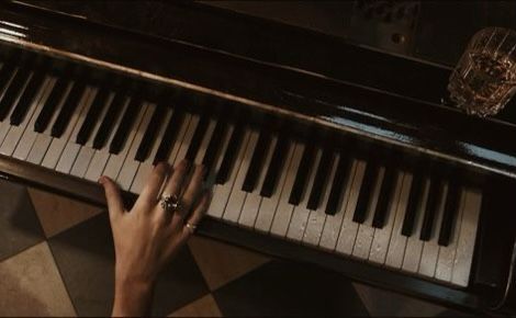 a person's hand on the keys of a piano