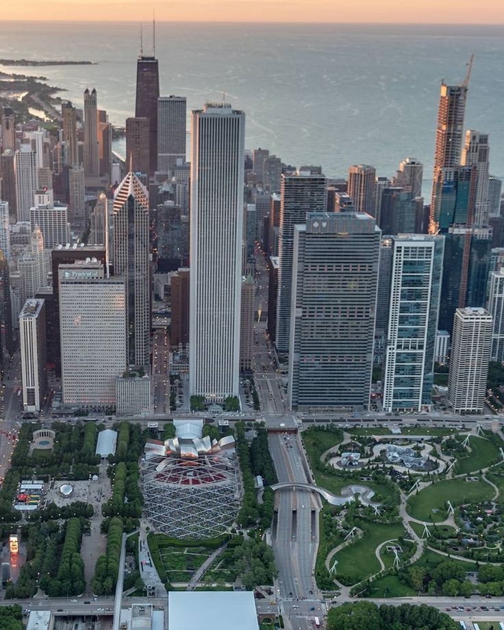 an aerial view of a large city with tall buildings and lots of green space in the foreground