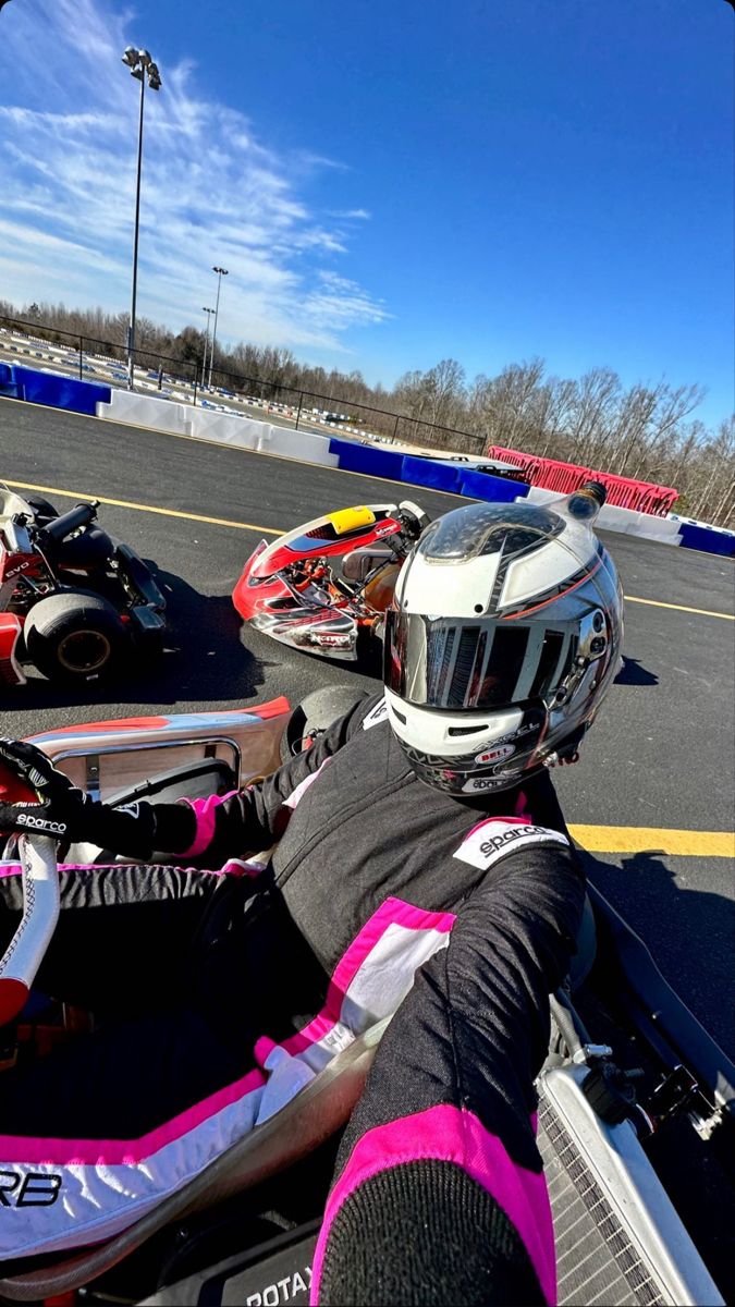 two motorcyclists wearing helmets sit on their bikes in a parking lot next to each other