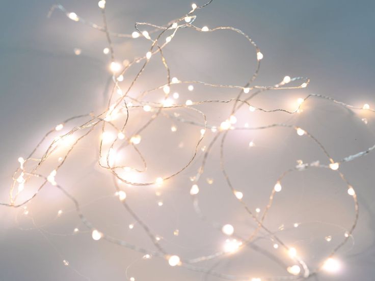 a bunch of white lights that are on a wall in front of a blue background