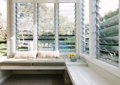 a white couch sitting next to a window in a living room