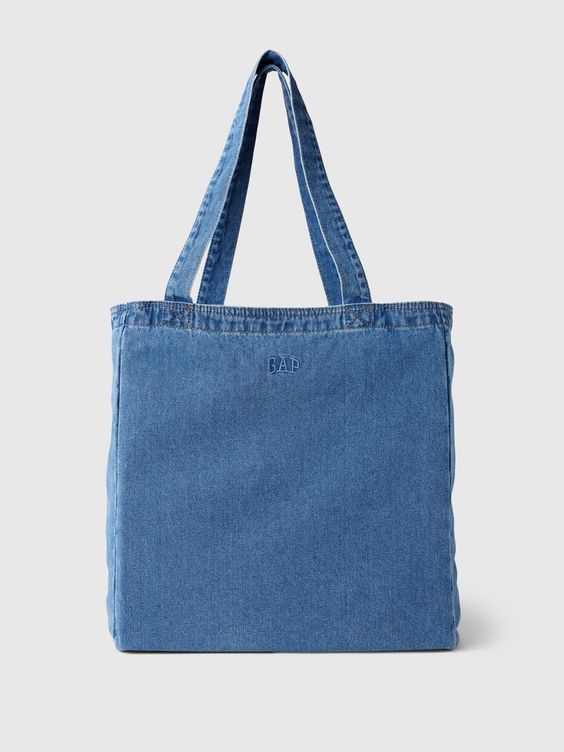 Soft denim tote bag.  Shoulder straps.  Inner pocket with zipper.  Embroidered mini Gap arch logo at front.  Responsibly Made: This denim bag s is part of our water-saving Washwell program.  Compared with conventional wash methods, Washwell uses at least 20% less water and has saved over a billion liters of water since 2016. 90s Street Style, Brain Storm, Denim Bag Patterns, Jean Purses, African Print Clothing, Arch Logo, Denim Handbags, Tote Bags Sewing, Denim Tote Bags