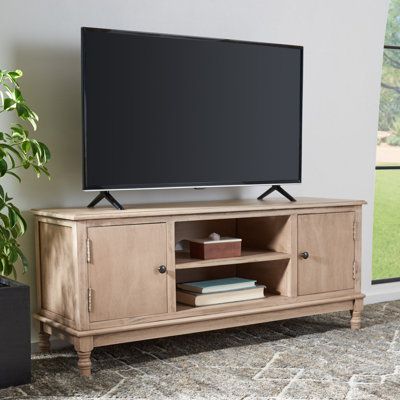 an entertainment center with a large flat screen tv on it's stand in front of a window