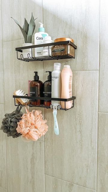 two black shelves holding hair care products and soaps on a tiled wall in a bathroom