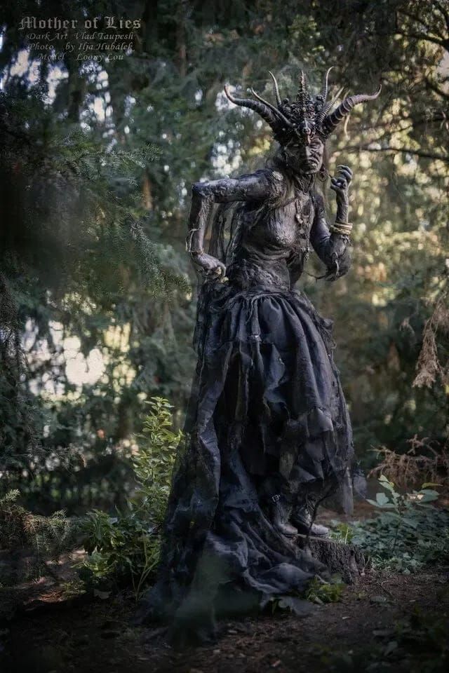 an instagramted photo of a woman dressed as a demon in the woods with trees