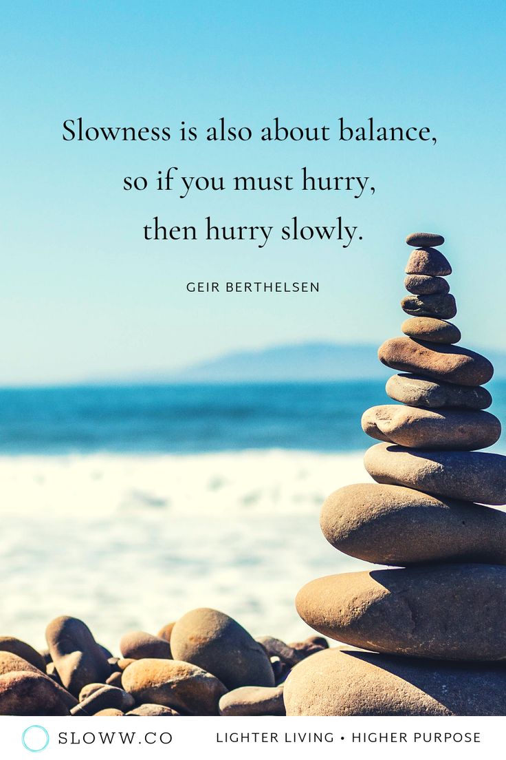 rocks stacked on top of each other in front of the ocean with a quote about slowness