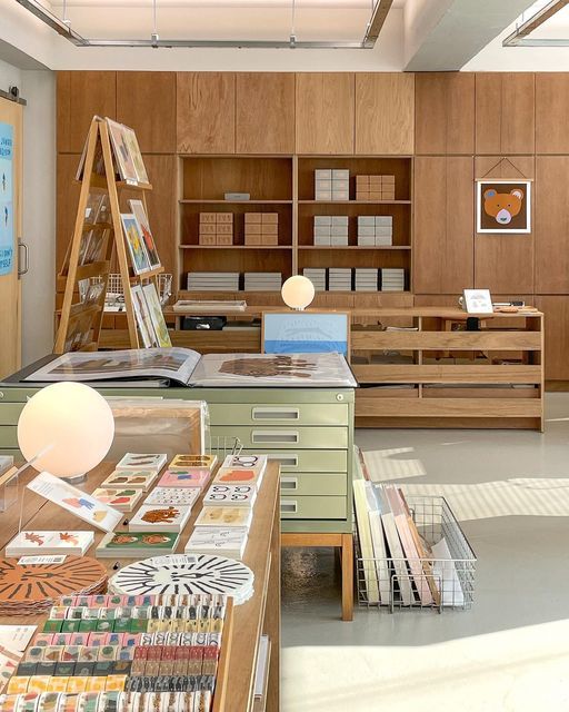 a room filled with lots of books and desks next to each other in front of wooden shelves