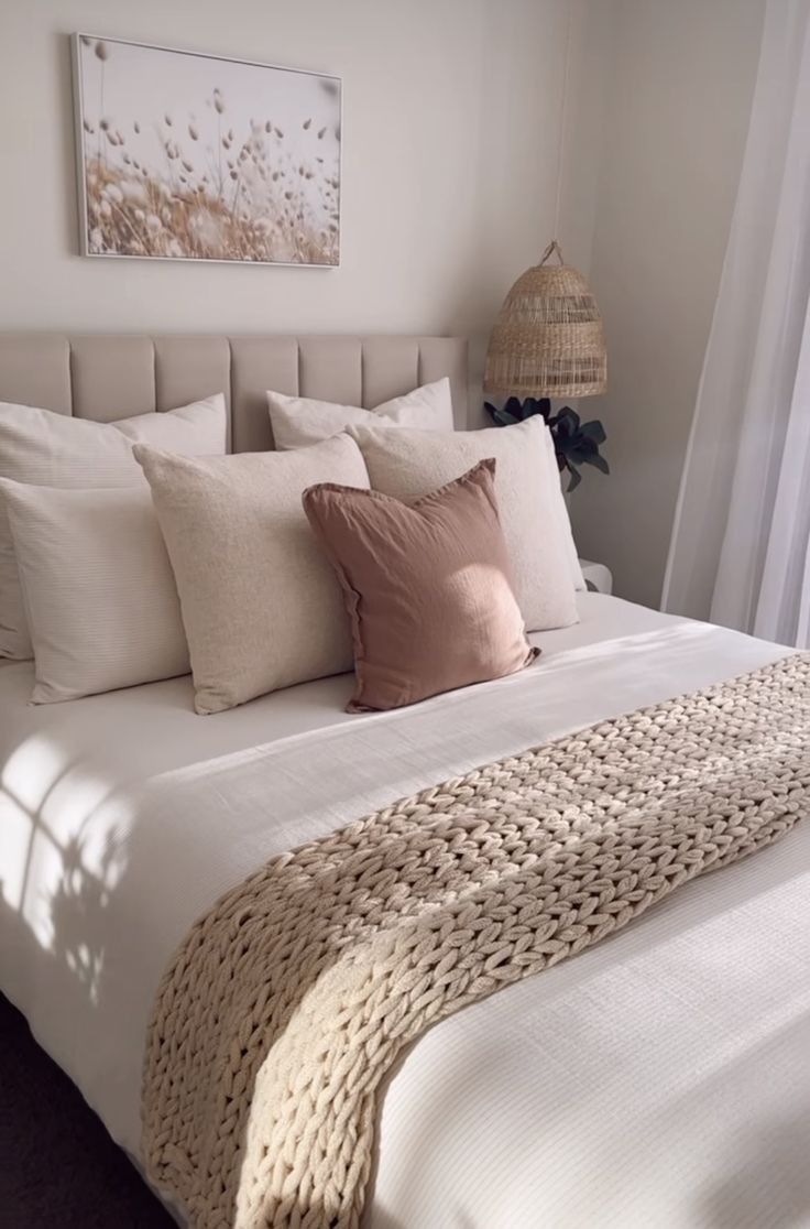 a bed with white sheets and pillows in a bedroom