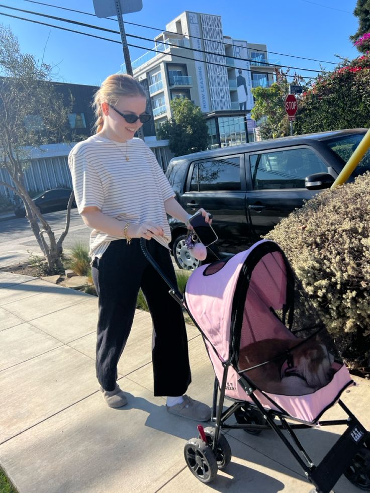 a woman pushing a stroller with a baby in it