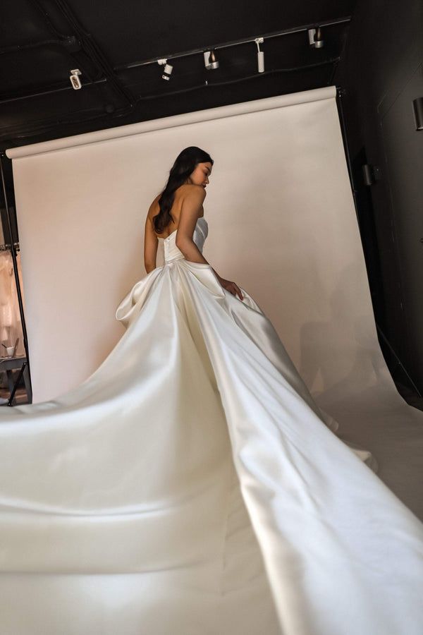 a woman in a white dress is posing for the camera