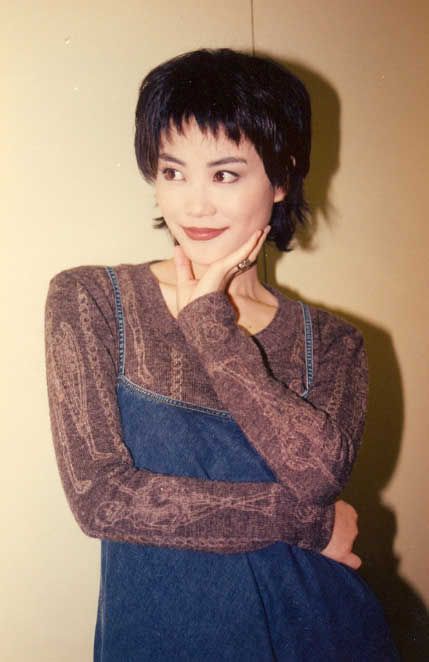 a woman with her arms crossed posing for the camera