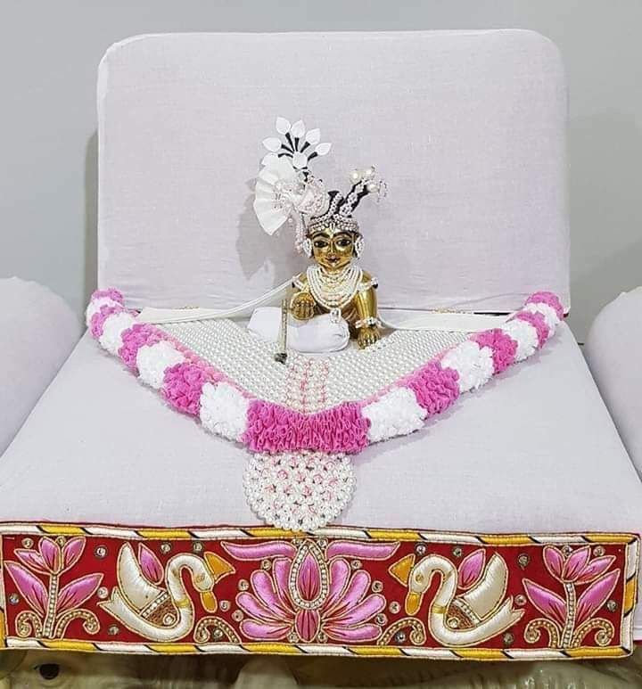 a white bed with pink and gold decorations on it