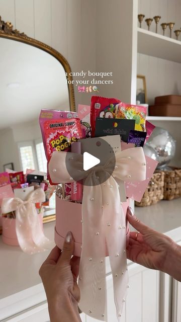 a person holding a pink gift box with candy in it on top of a counter