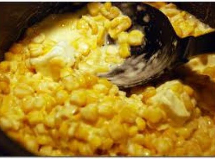 corn being cooked in a pot with a ladle