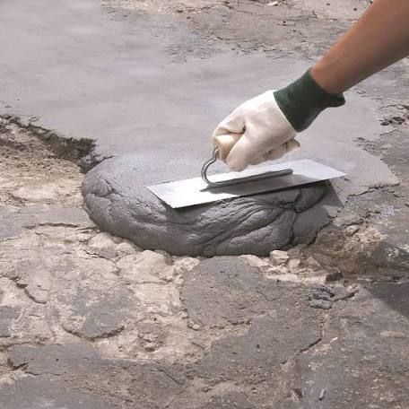 a person in white gloves is using a trowel