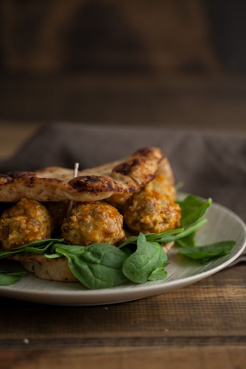 meatballs and spinach on a plate with toothpicks in the middle, ready to be eaten