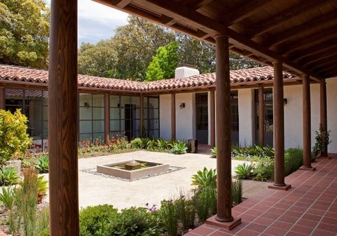 an outdoor courtyard with brick pavers and potted plants