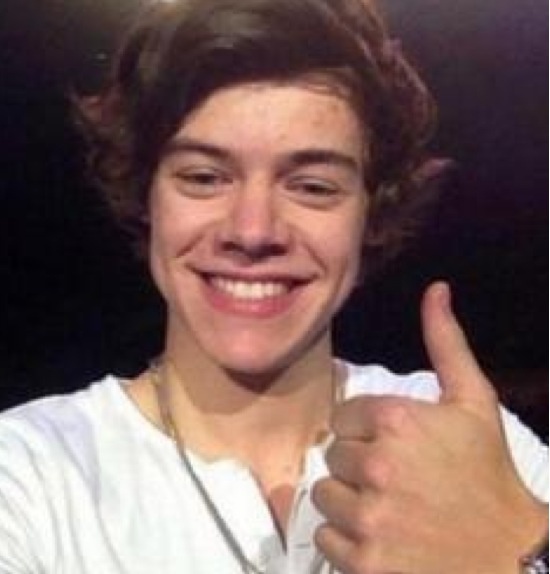 a young man giving the thumbs up sign in front of his face and wearing a white shirt