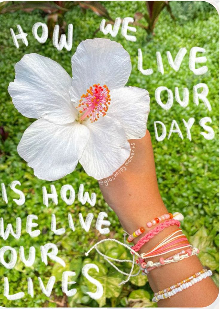 a woman's hand holding a white flower with the words how we live our days on it