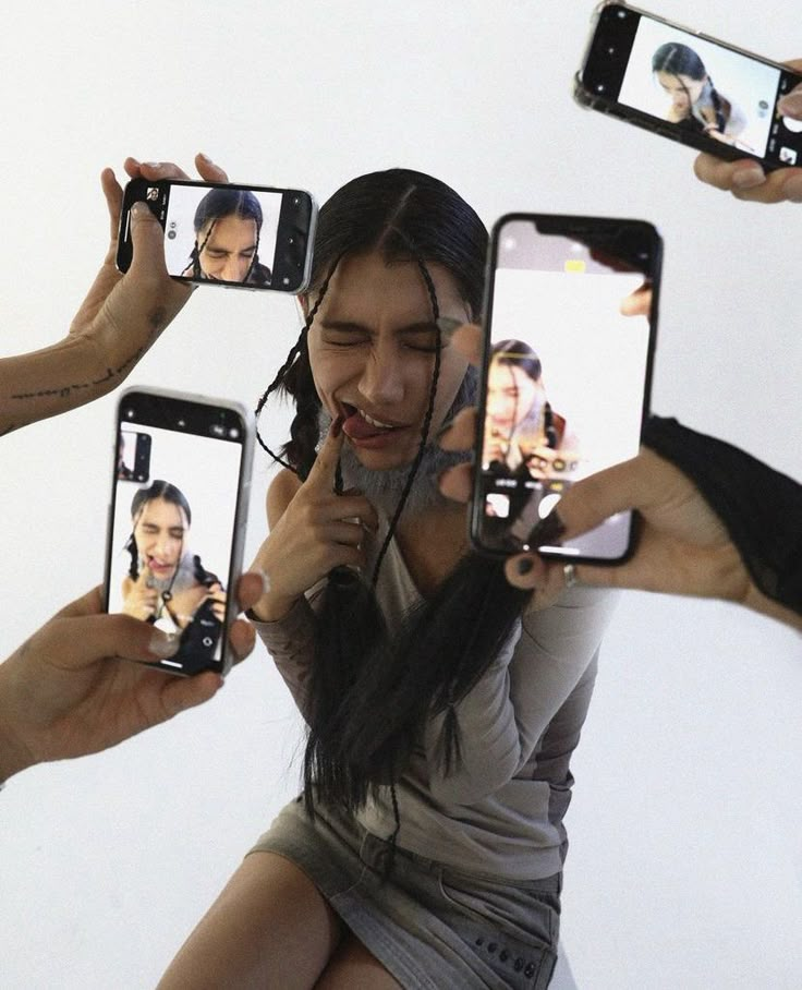 a group of people holding up their cell phones to take pictures with the same person