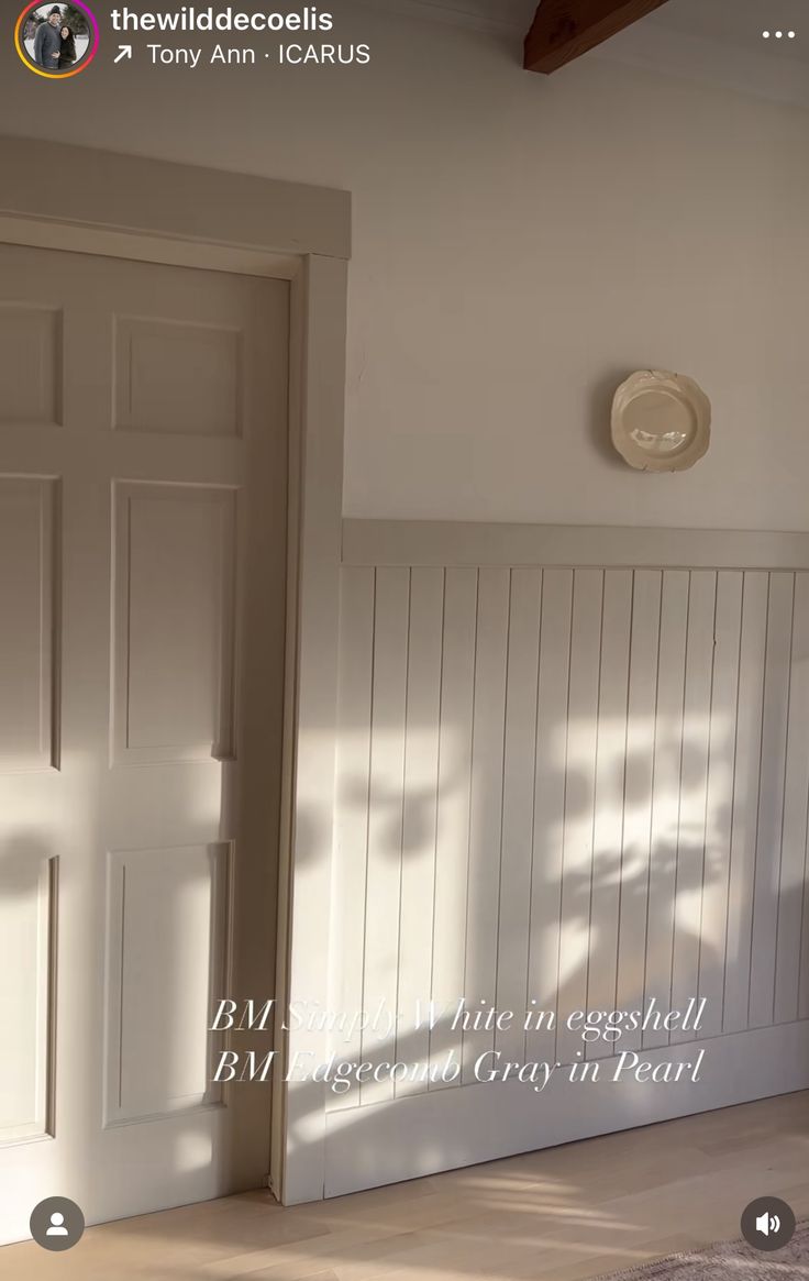 an empty room with white paneling on the walls