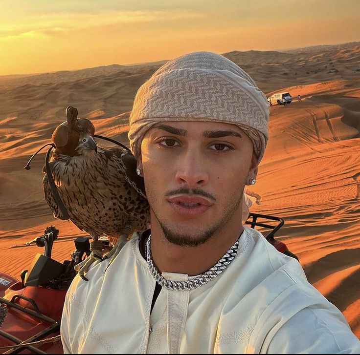 a man with a bird on his shoulder in the desert