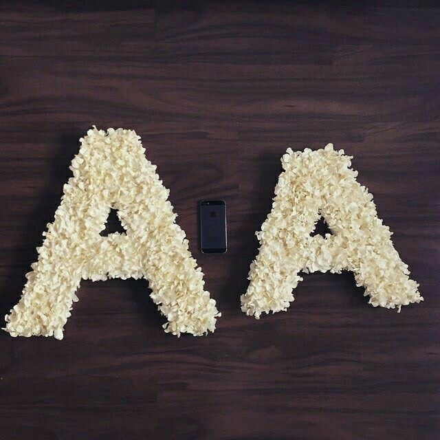 the letters are made out of rice and next to a cell phone on a table